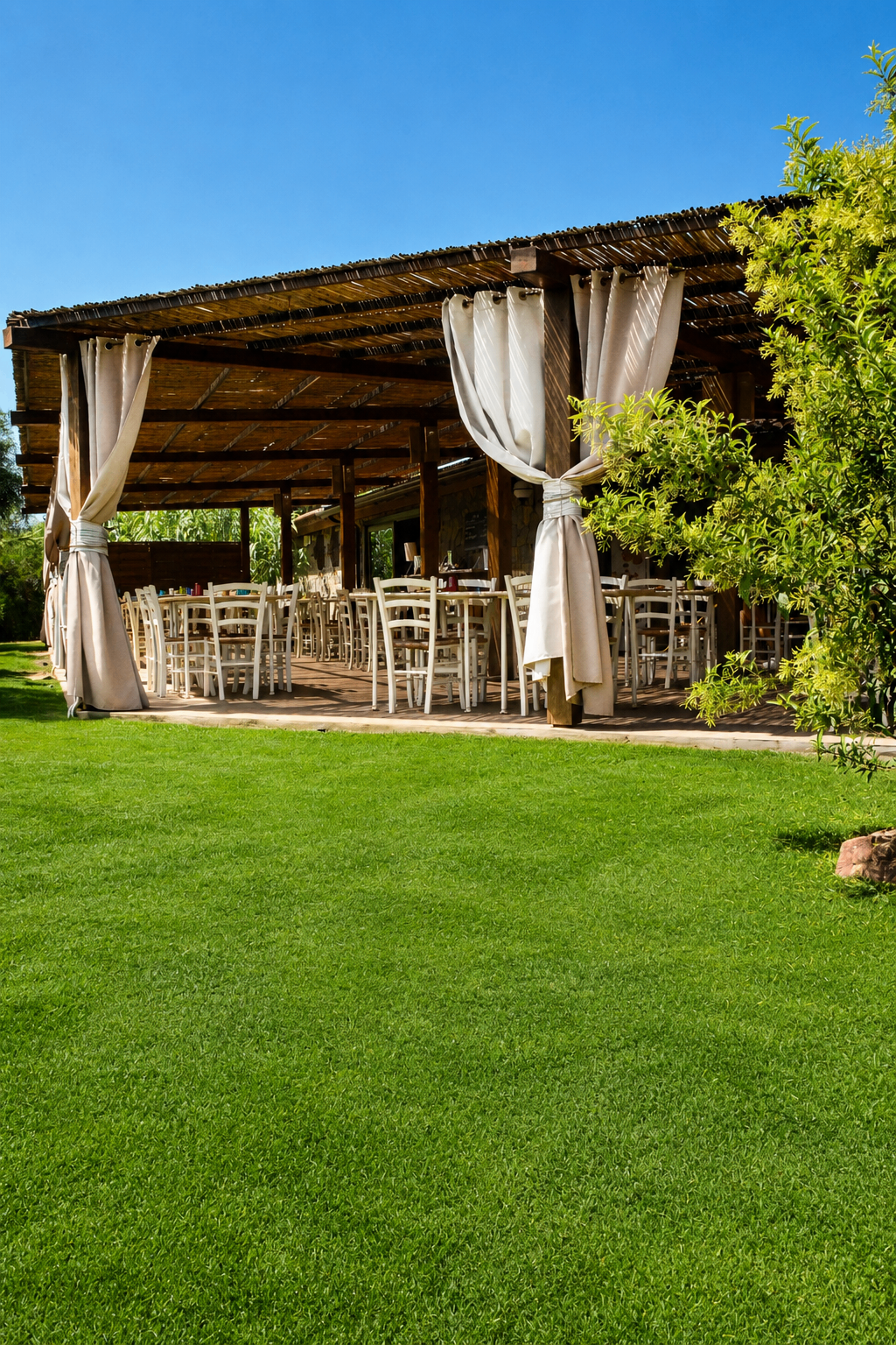 Pergola e prato del Club Nautico Chia affacciati sul mare
